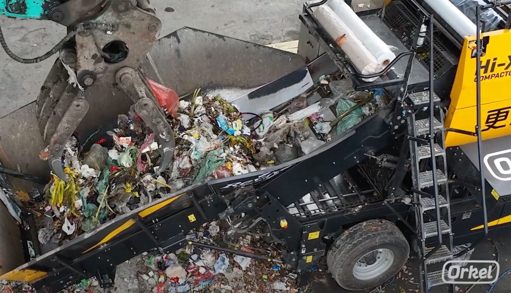Close up of a conveyor belt being filled up with household waste.